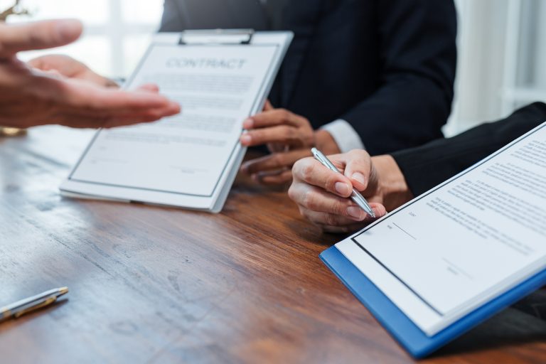 Team meeting discussing commercial legal issues and contract obligations